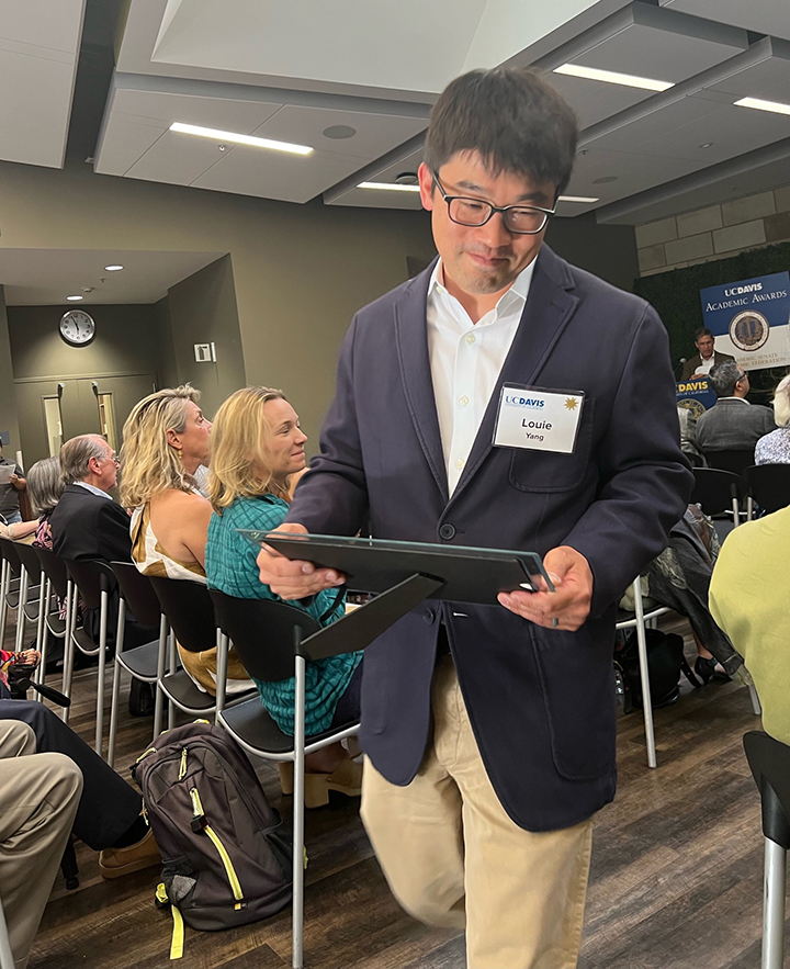 Professor Louie Yang returns to his seat after accepting an Academic Senate award