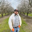 Joseph Tauzer, manager of the Harry H. Laidlaw Jr. Honey Bee Research Facility, in Hamilton City almond orchard. (Photo by Kian Nikzad)